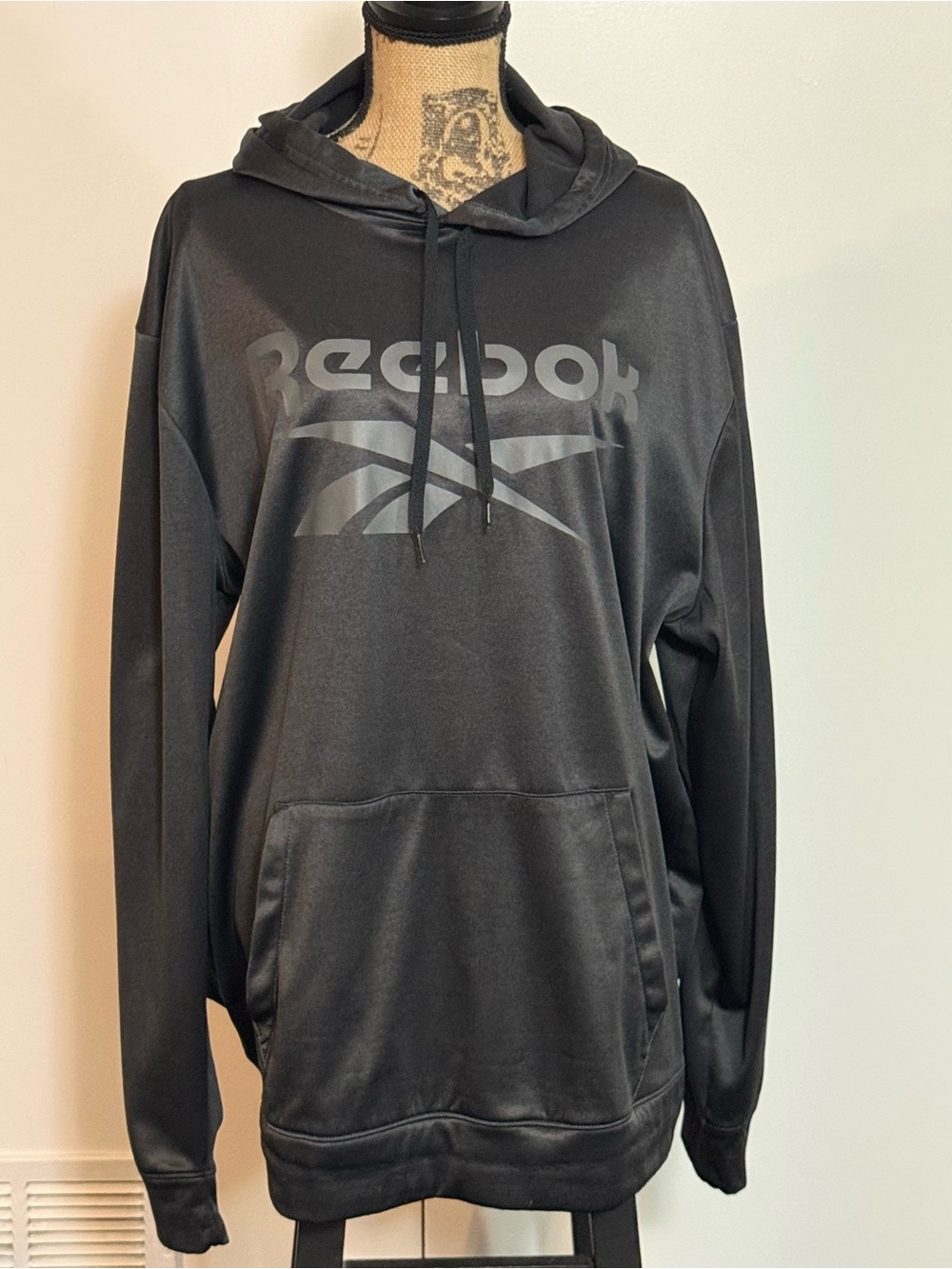Reebok Black Pullover Hoodie with Tonal Logo and front kangaroo pocket.